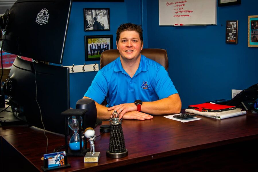 Castle Electric owner Jim Jr sitting at office desk
