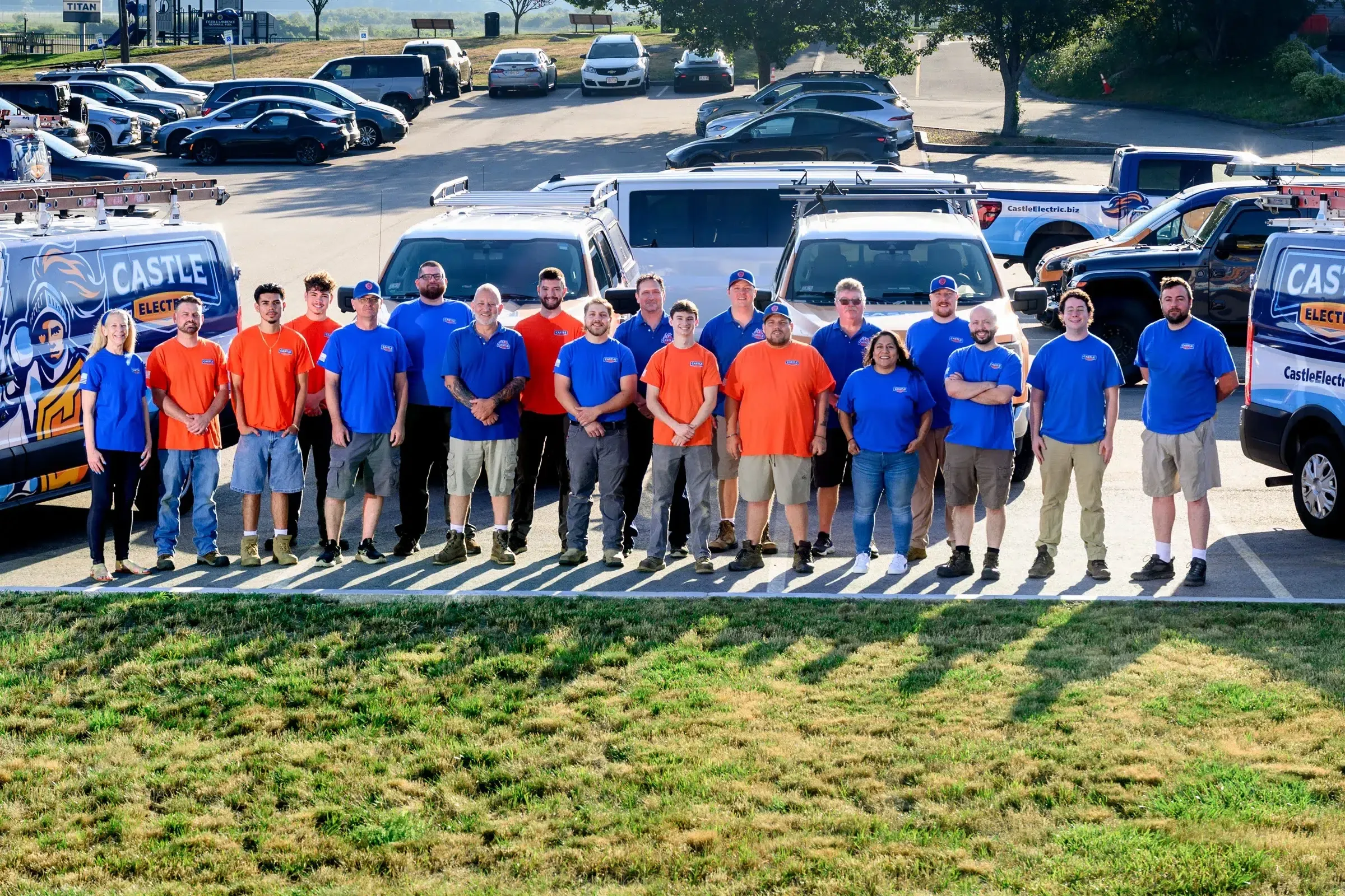 The Castle Electric team standing in front of the company van fleet