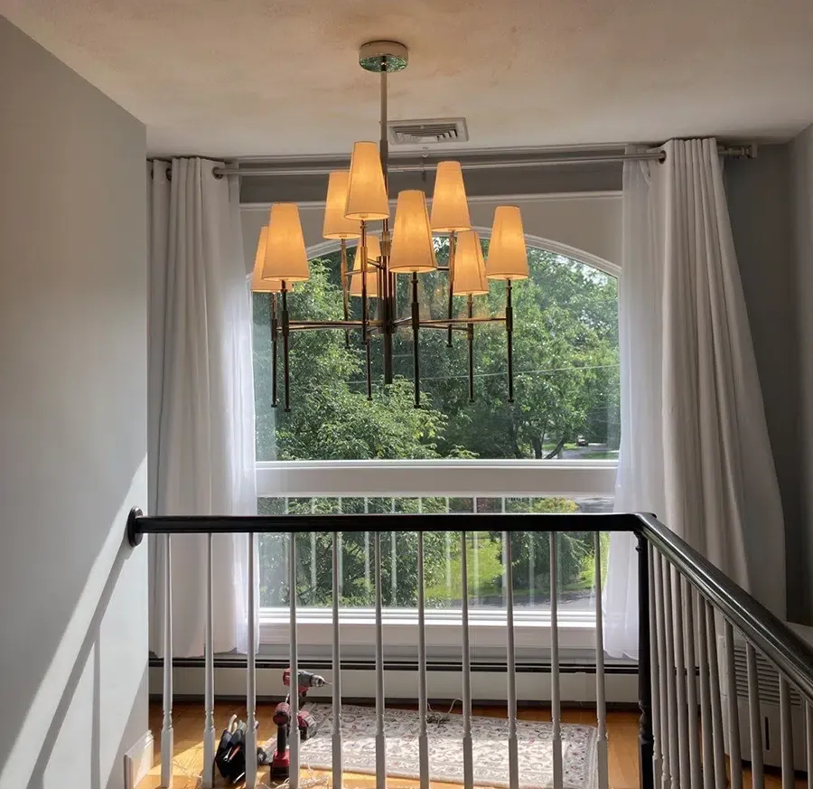 Multi-shade chandelier installed by Castle Electric in a Newton MA home stairwell landing