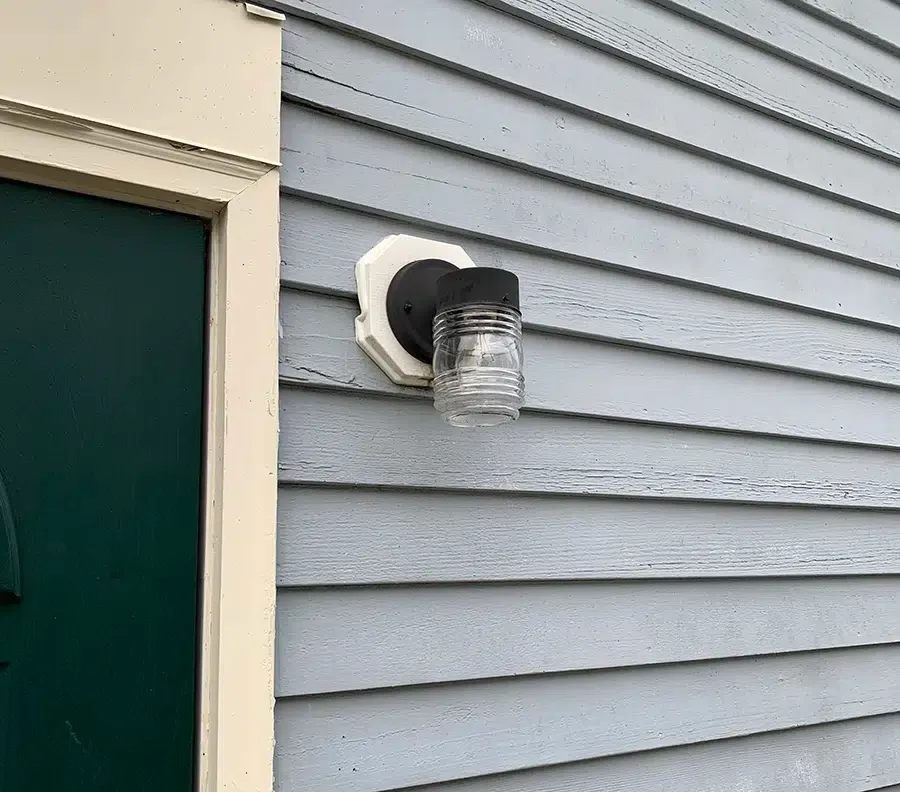 Black jelly jar outdoor wall light installed beside entry door on Eastern Massachusetts home by Castle Electric