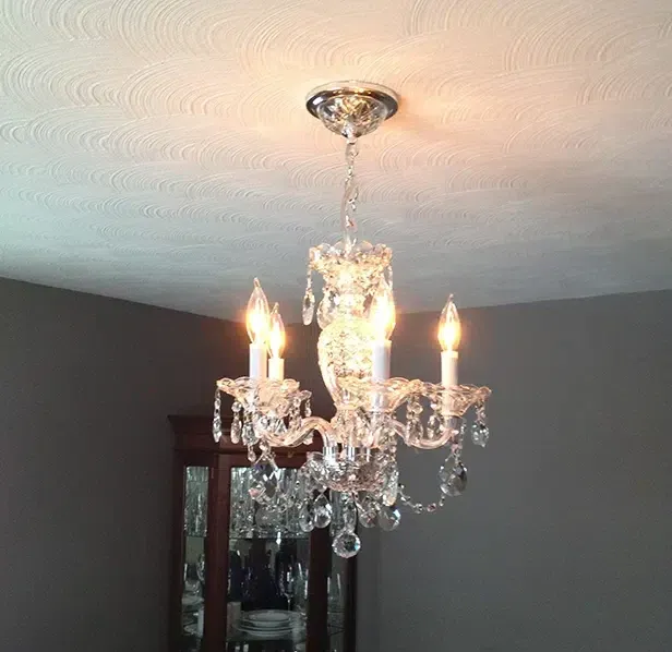 Elegant crystal chandelier installation in an Eastern Massachusetts dining room by Castle Electric Inc.