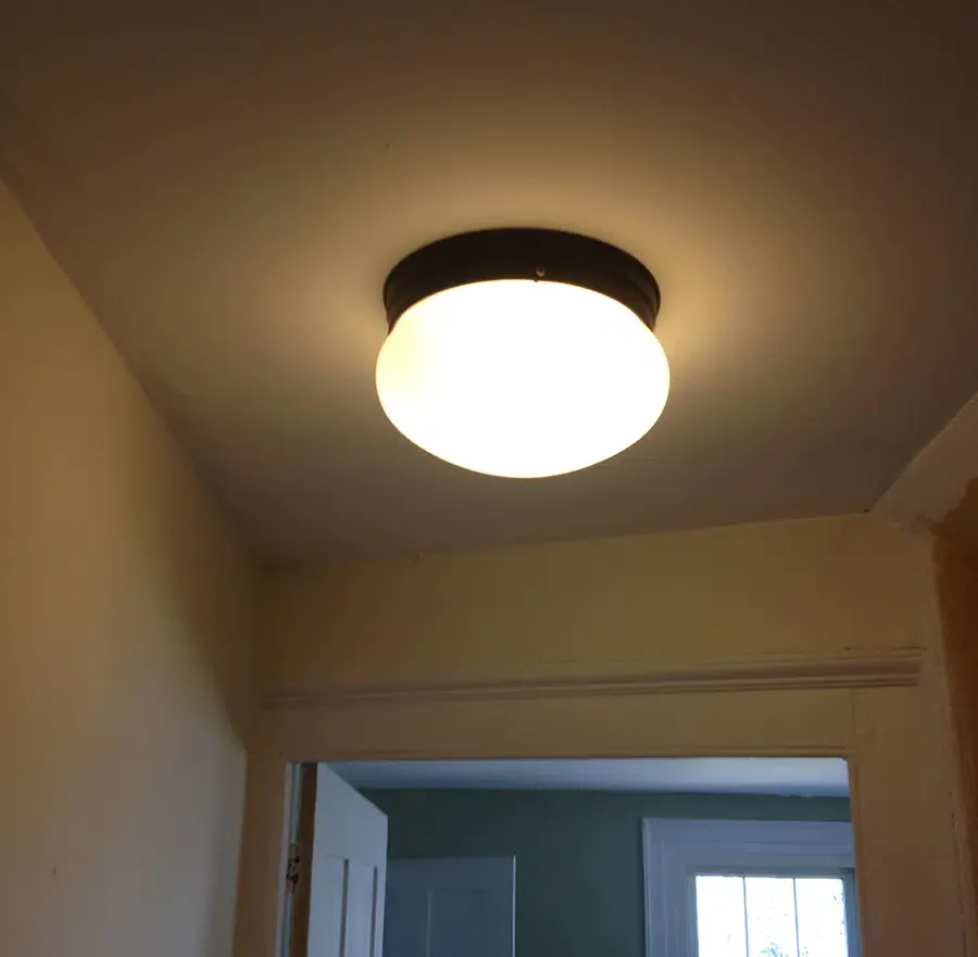 Bronze flush-mount ceiling light installed in a Norwood MA hallway by a licensed Castle Electric electrician