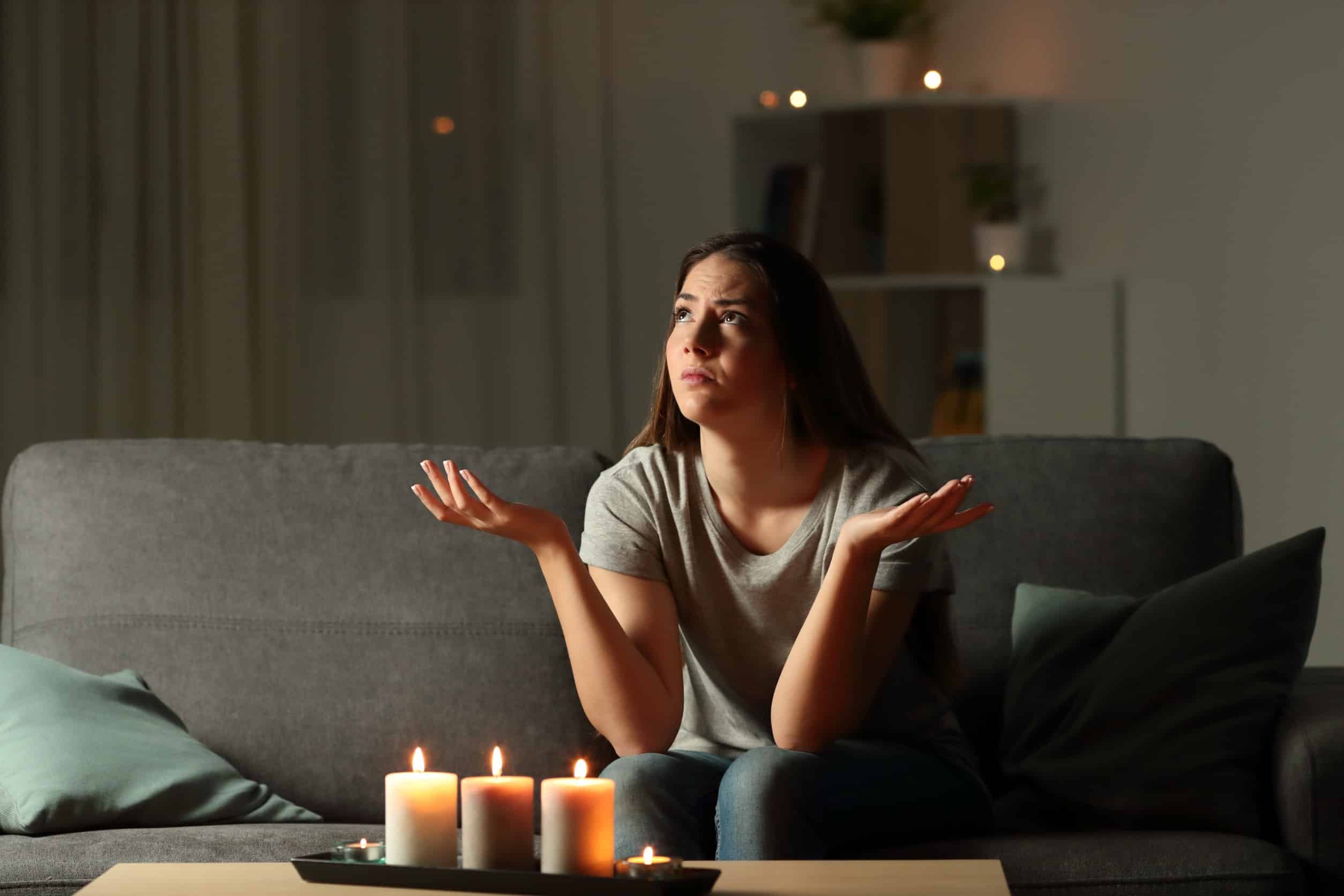 woman sitting in the living room with candles because the power went out
