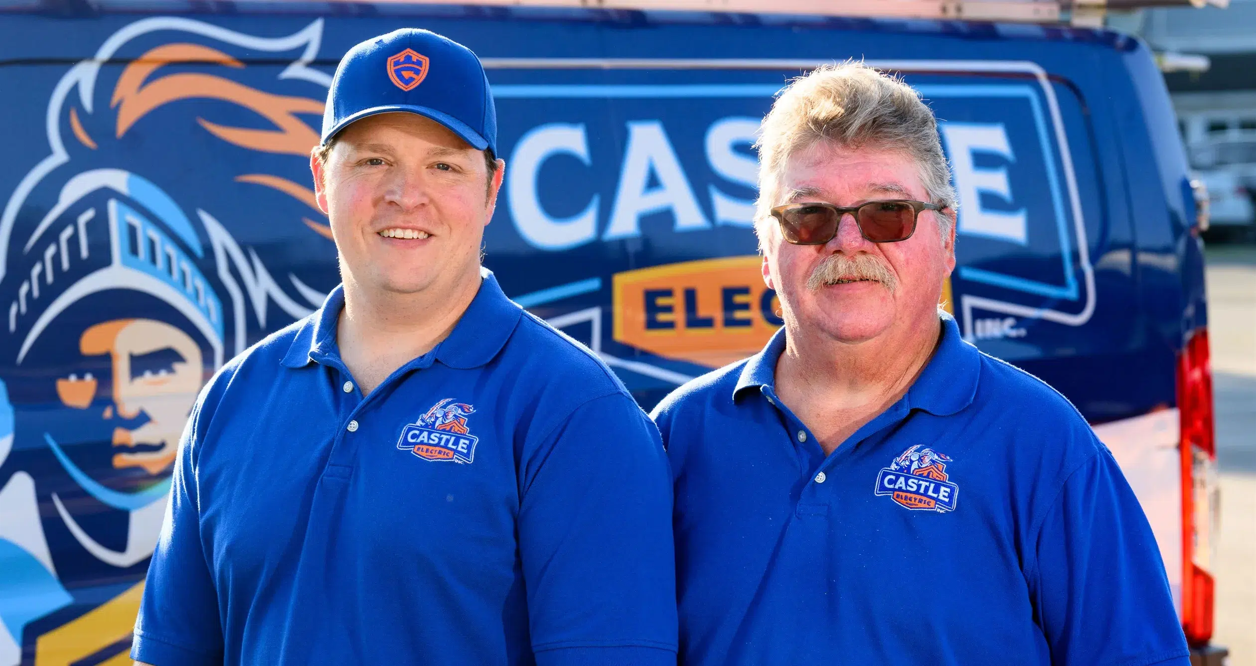 Jim Prescott Jr and Jim Prescott Sr, owners of Castle Electric, in front of a company van