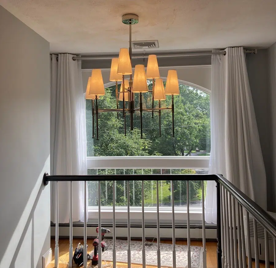 Multi-shade chandelier installed by Castle Electric in a Newton MA home stairwell landing